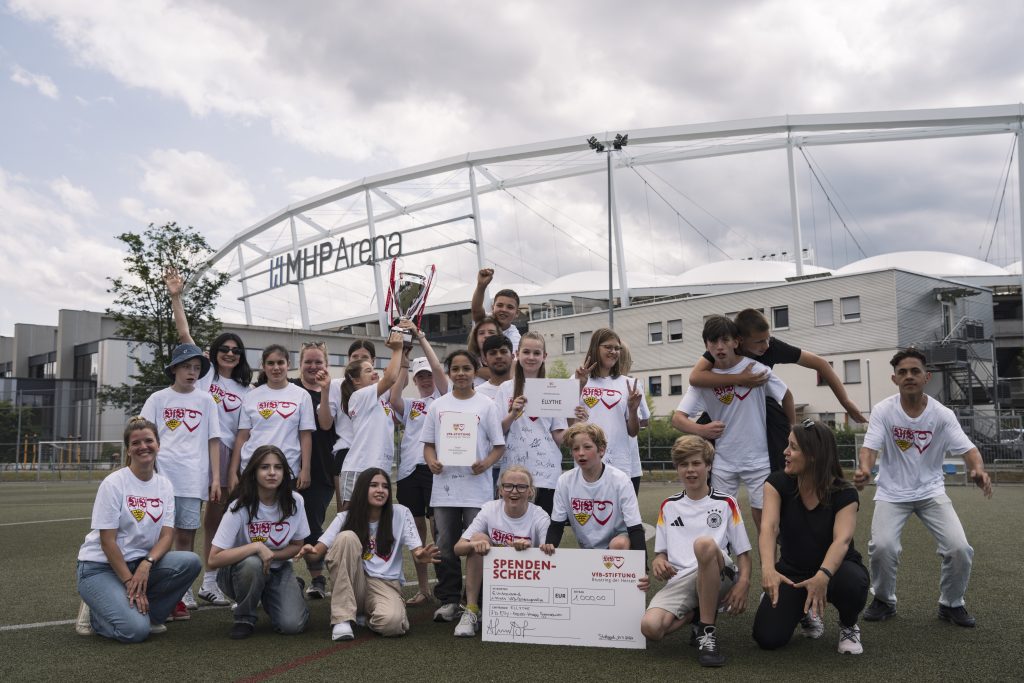 Die Kinder der 7B des Elly-Heuss-Knapp-Gymnasiums aus Stuttgart-Bad Cannstatt jubeln mit dem Pokal über den Gewinn der VfB-Bildungsrallye.