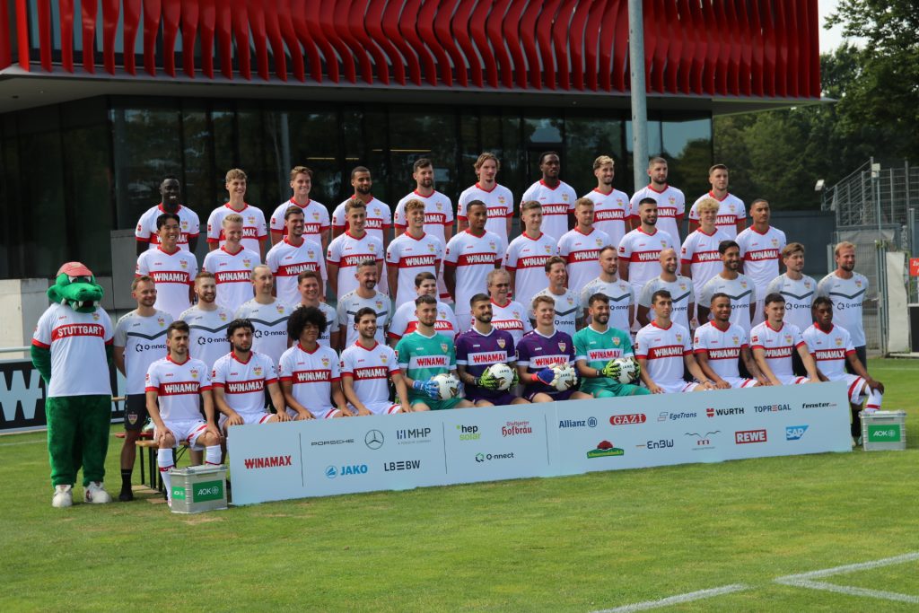 Die Gewinnerinnen der VIPrize-Verlosung 2024 inmitten der VfB-Mannschaft beim Fotoshooting für das Mannschaftsfoto